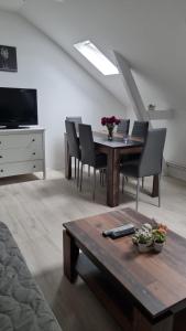 uma sala de estar com uma mesa de madeira e cadeiras em Stadtnah an der Förde 75 3 em Flensburg