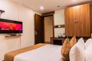 a hotel room with a bed and a flat screen tv at TGI Felicity in Bangalore
