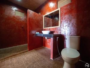 a red bathroom with a toilet and a sink at Bottle Beach 2 Bungalows in Bottle Beach