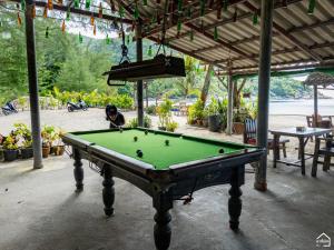 a pool table in a pavilion with a dog behind it at Bottle Beach 2 Bungalows in Bottle Beach