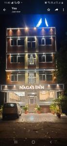 a building with a car parked in front of it at Nagas Inn by Unicorn in Krishnagiri