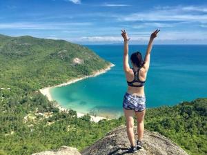 a woman standing on top of a rock overlooking the ocean at Bottle Beach 2 Bungalows in Bottle Beach