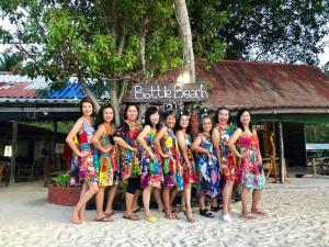 a group of girls in dresses posing for a picture on the beach at Bottle Beach 2 Bungalows in Bottle Beach