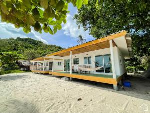 a house on the beach with a building at Bottle Beach 2 Bungalows in Bottle Beach