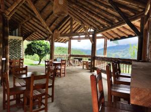 a restaurant with tables and chairs and a view of mountains at Hass Glamping Jericó in Jericó
