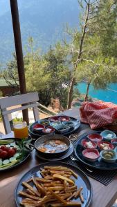 a table topped with plates of food and french fries at Kabak Ütopya Suites in Faralya