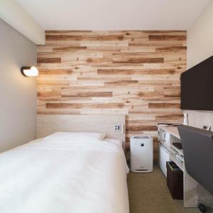 1 dormitorio con 1 cama y pared de madera en Super Hotel Tokyo JR Kamata Nishiguchi, en Tokio