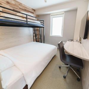 a bedroom with a bunk bed and a desk and a chair at Super Hotel Tokyo JR Kamata Nishiguchi in Tokyo