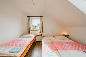 two beds in a small room with a window at Na Želivce chalupa Gabriela in Želiv