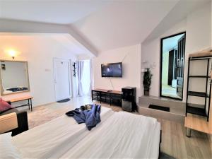 a large white room with a bed and a tv at Casa Eladi in Eforie Sud