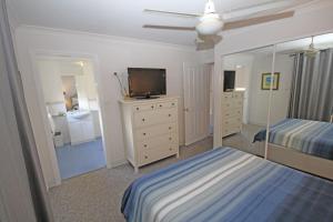 een slaapkamer met 2 bedden, een tv en een spiegel bij Paradise Waters 13 in Coffs Harbour +14 foto's