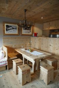a kitchen with a large wooden table and benches at Neve e Sole in Selva di Val Gardena