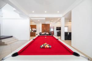 una mesa de billar con pelotas en la sala de estar en Wongamart Pool Villa en Pattaya North