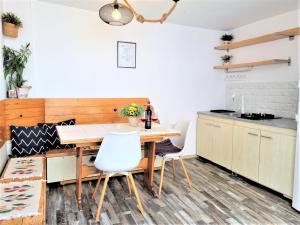 a kitchen and dining room with a wooden table and chairs at Casa Eladi in Eforie Sud