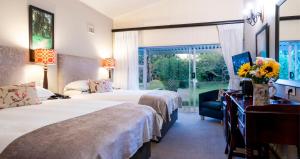 Habitación de hotel con 2 camas y ventana en ANEW Resort Ingeli Forest Kokstad en Kokstad