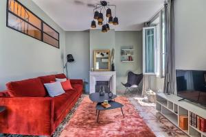 ein Wohnzimmer mit einem roten Sofa und einem Kamin in der Unterkunft La Maison in Istres