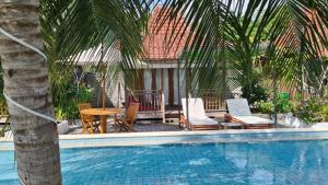 a pool with chairs and a table and a palm tree at Panorama Ekas in Ekas