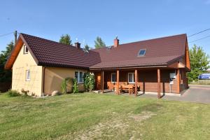 una casa con tetto marrone e cortile di Stokrotka a Białowieża