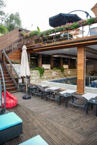 a resort with a pool and tables and an umbrella at Zarevata Guest House in Velingrad