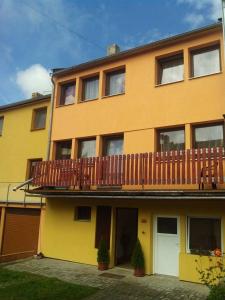 a yellow building with a deck on top of it at Apartmány Mimpi in Frymburk
