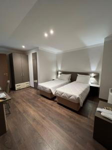 two beds in a room with wooden floors at Locanda Aquila Nera in Aquiléia