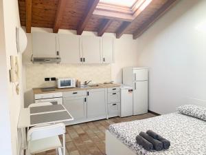 a kitchen with white cabinets and a table and a bed at Casa Cleopatra in Bergamo