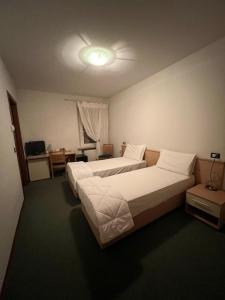 a hotel room with two beds and a desk at Locanda Aquila Nera in Aquiléia