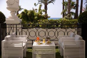 a group of white chairs and a table with food on it at Hotel Le Negresco in Nice