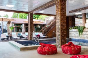 two red bean bags sitting on a patio with a pool at Zarevata Guest House in Velingrad