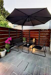 a patio with an umbrella and two chairs and a table at Elia Room & Garden II (new entry) in Kontokali