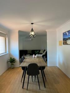 Archipelago Apartments Esperance في إسبيرانس: طاولة طعام وكراسي في غرفة المعيشة