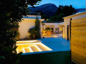 a house with lights on a driveway at night at Zlatni Rat Beach Resort in Bol