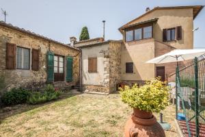 a house with a yard in front of it at Casa Vacanze del Borgo in Montalcino +18 photos