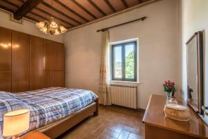 a bedroom with a bed and a window and a table at Casa Vacanze del Borgo in Montalcino
