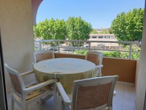 stół i krzesła na balkonie z widokiem w obiekcie PORT FREJUS Studio Cabine 100m des plages 4 Person w Fréjus