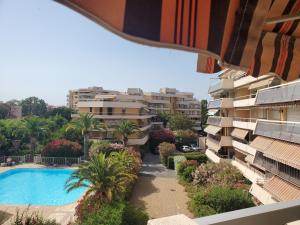 een uitzicht vanaf het balkon van een gebouw met een zwembad bij MIOUGRANO 2 Pieces Climatise 47m2 Piscine, Parking in Fréjus