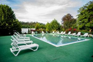 Dumbrăveni的住宿－HOTEL MARION POIANA，一组白色躺椅和一个游泳池