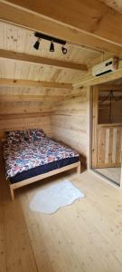 Zimmer mit einem Bett in einer Holzhütte in der Unterkunft Domek z Sauną i balią jakuzii w głuszy 