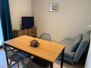a living room with a table and a couch at Appartement avec Terrasse et piscine in Gréoux-les-Bains