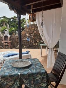 a patio with a table and a chair at Guest House Ysabela Suite Privada y Habitaciones con Baño Compartido in Tías