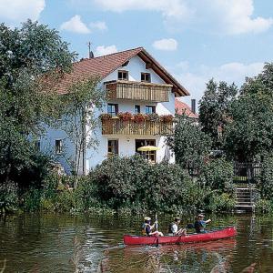 un grupo de personas en una canoa roja en un río en Pension Agathe, en Beilngries