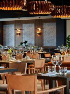 a restaurant with empty tables and chairs with wine glasses at Hotel Bergo Resort & SPA in Szklarska Poręba