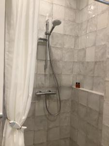 La salle de bains est pourvue d'une douche avec rideau de douche. dans l'établissement Vila MAY, à Juodkrantė
