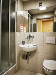 La salle de bains est pourvue d'un lavabo et de toilettes. dans l'établissement Dom Studencki Zaułek, à Cracovie