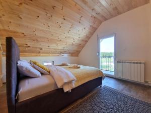 a bedroom with a large bed with a wooden ceiling at Apartmani Gala Žabljak in Žabljak