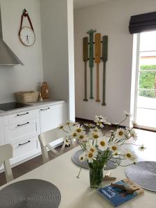 un vase de fleurs sur une table dans une cuisine dans l'établissement Vila MAY, à Juodkrantė