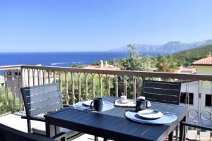 un tavolo blu su un balcone con vista sull'oceano di Appartamento vista Golfo a Cala Gonone