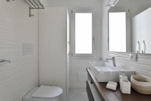 un bagno bianco con lavandino e WC di Appartamento vista Golfo a Cala Gonone Altre 18 foto