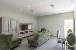 uma sala de estar com duas cadeiras e uma televisão em Apartamento Torero II em Marchena