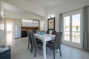 卡拉古諾內的住宿－Appartamento vista Golfo，用餐室以及带白色桌椅的厨房